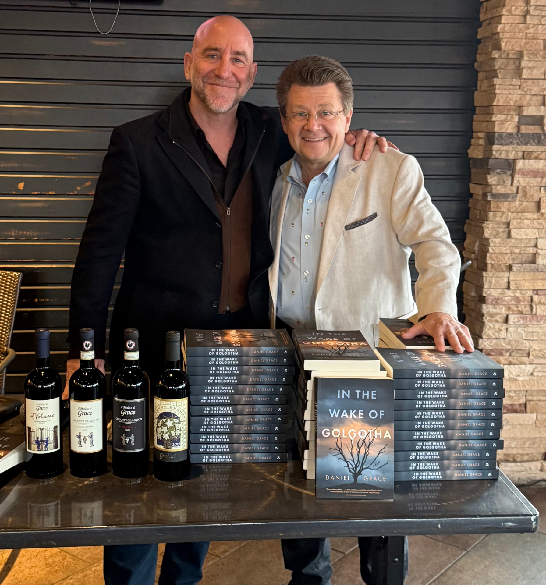 Daniel Grace at Beau's Grille book release with stacks of In the Wake of Golgotha